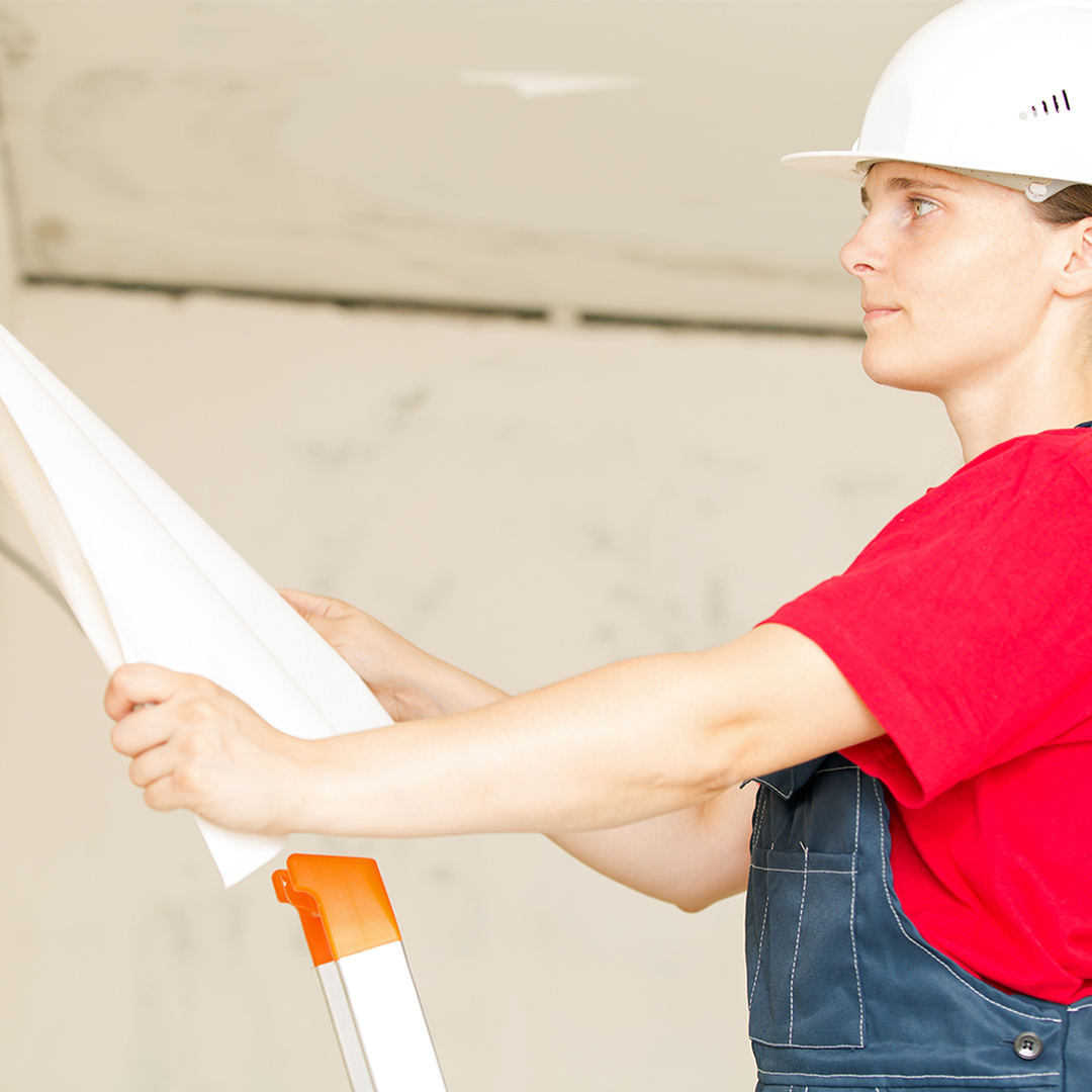 woman in hard hat holding blueprints