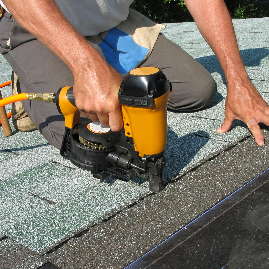 roofer nailing down shingles