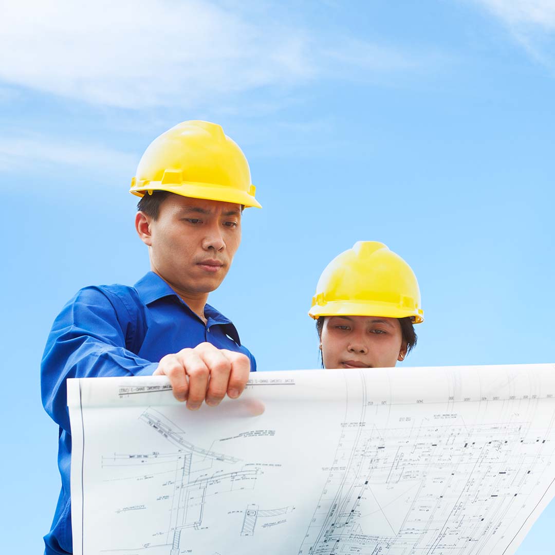 A couple of contractors looking over a blueprint