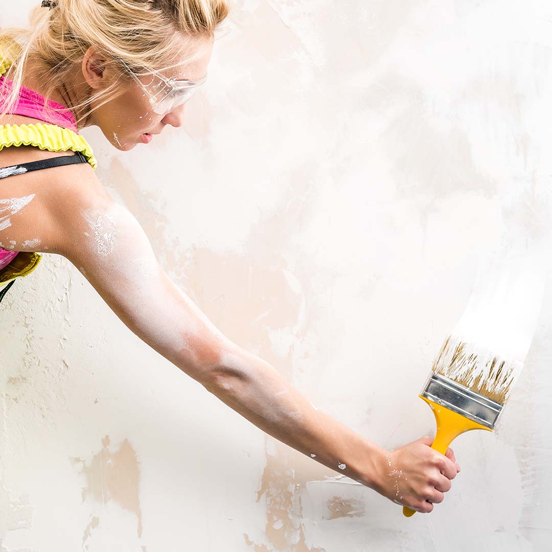 A female contractor painting a wall